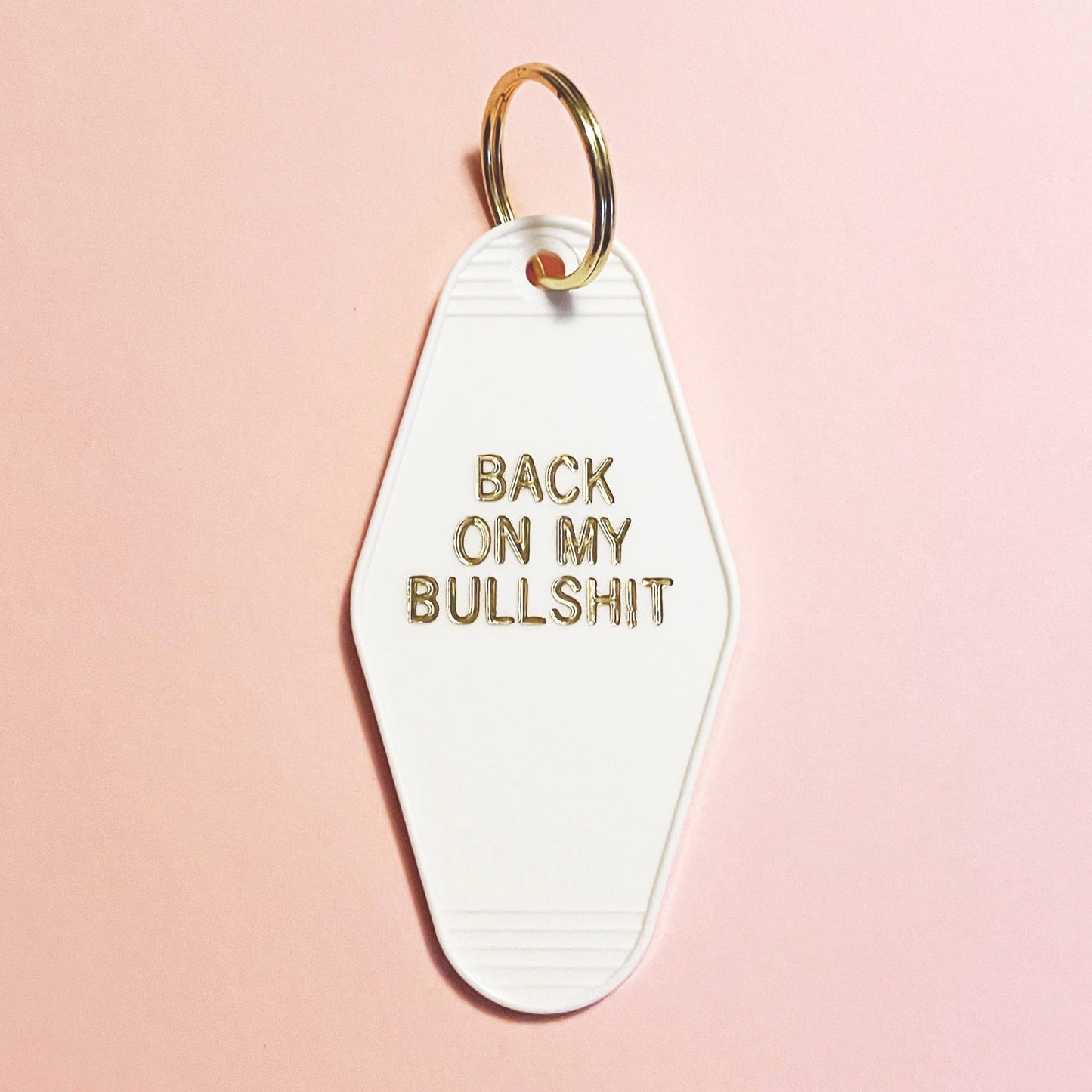 Back on my bullshit retro motel keychain, white with gold lettering